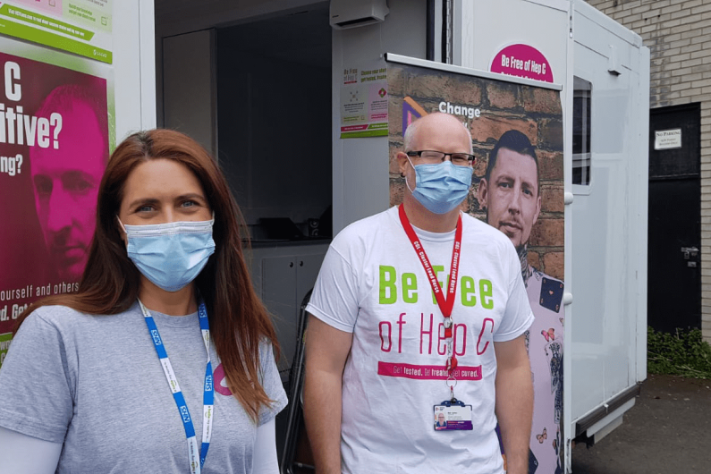 two people stood in front of a hepatitis c testing van