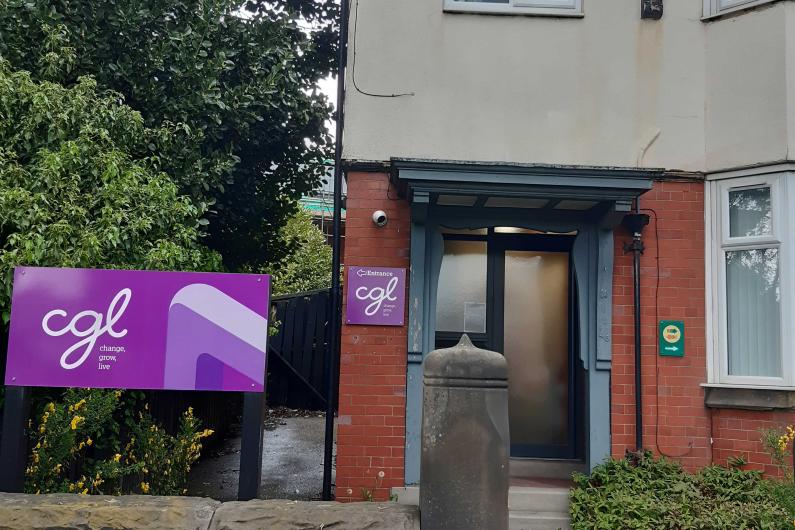 Outside the Macclesfield Building - CGL sign, a wall, and a mock Tudor building