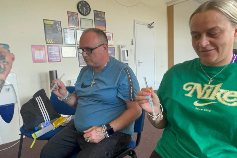 Two people holding naloxone kits