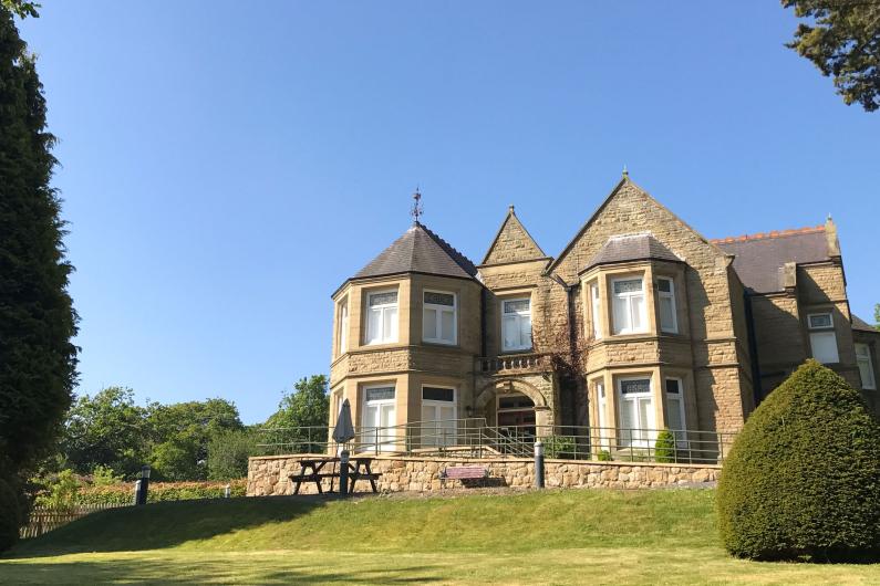 An old Victorian mansion with a sprawling garden