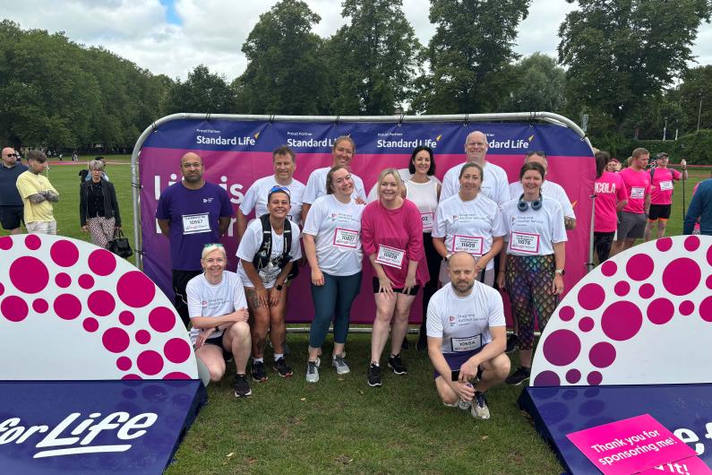 A group of people stood in front of Race for Life banners