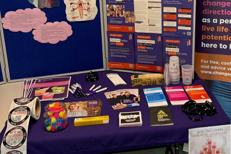 A table with a display board on it with information and posters around Alcohol awareness week