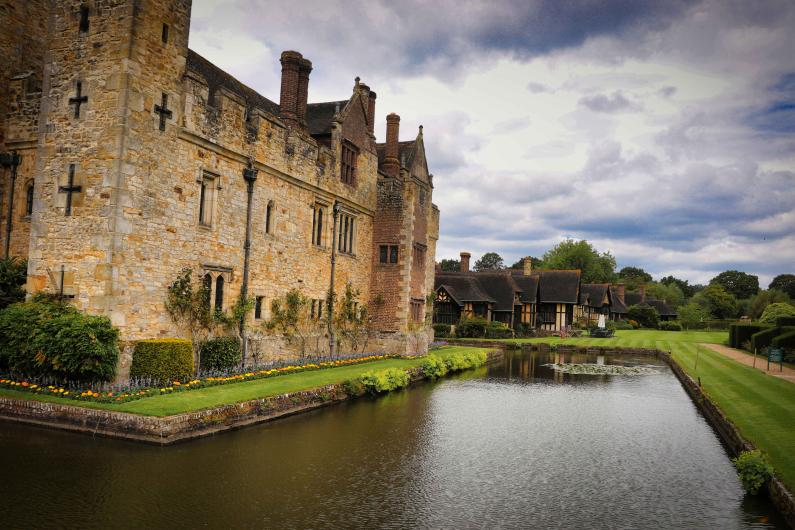 The outside of an old castle with a moat around it