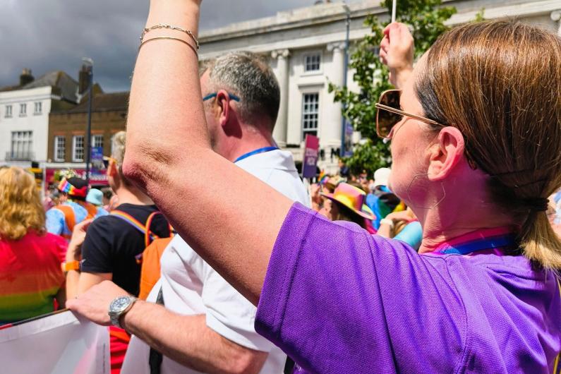 A women in a parade waving a pride flag