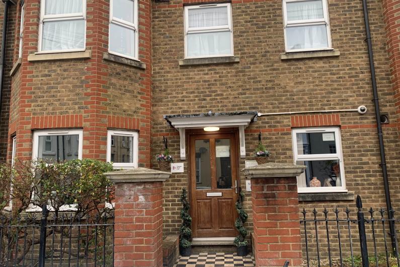 A red brick house with steps leading up to the front door.