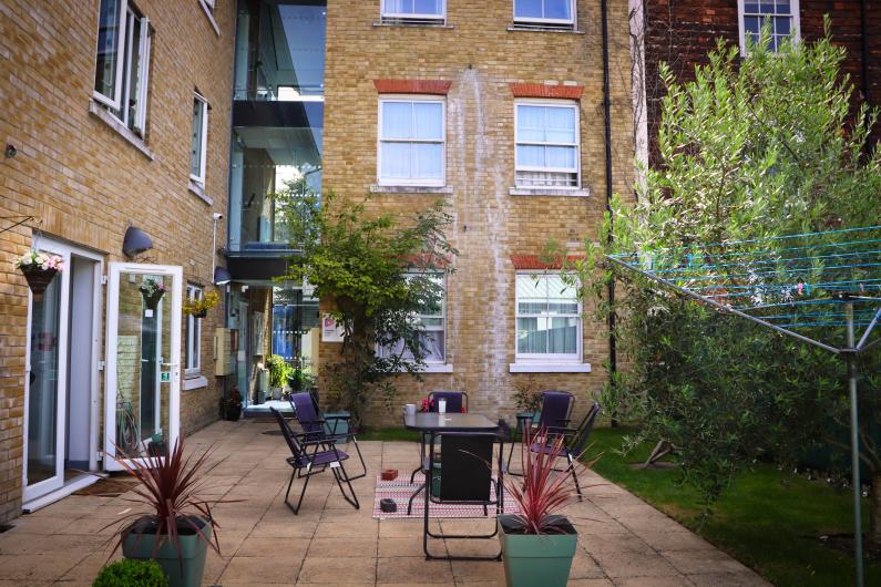 A small courtyard garden with a table and chairs 