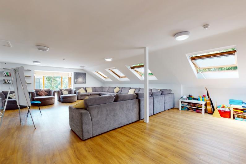 An open, airy room with sofas around the edge