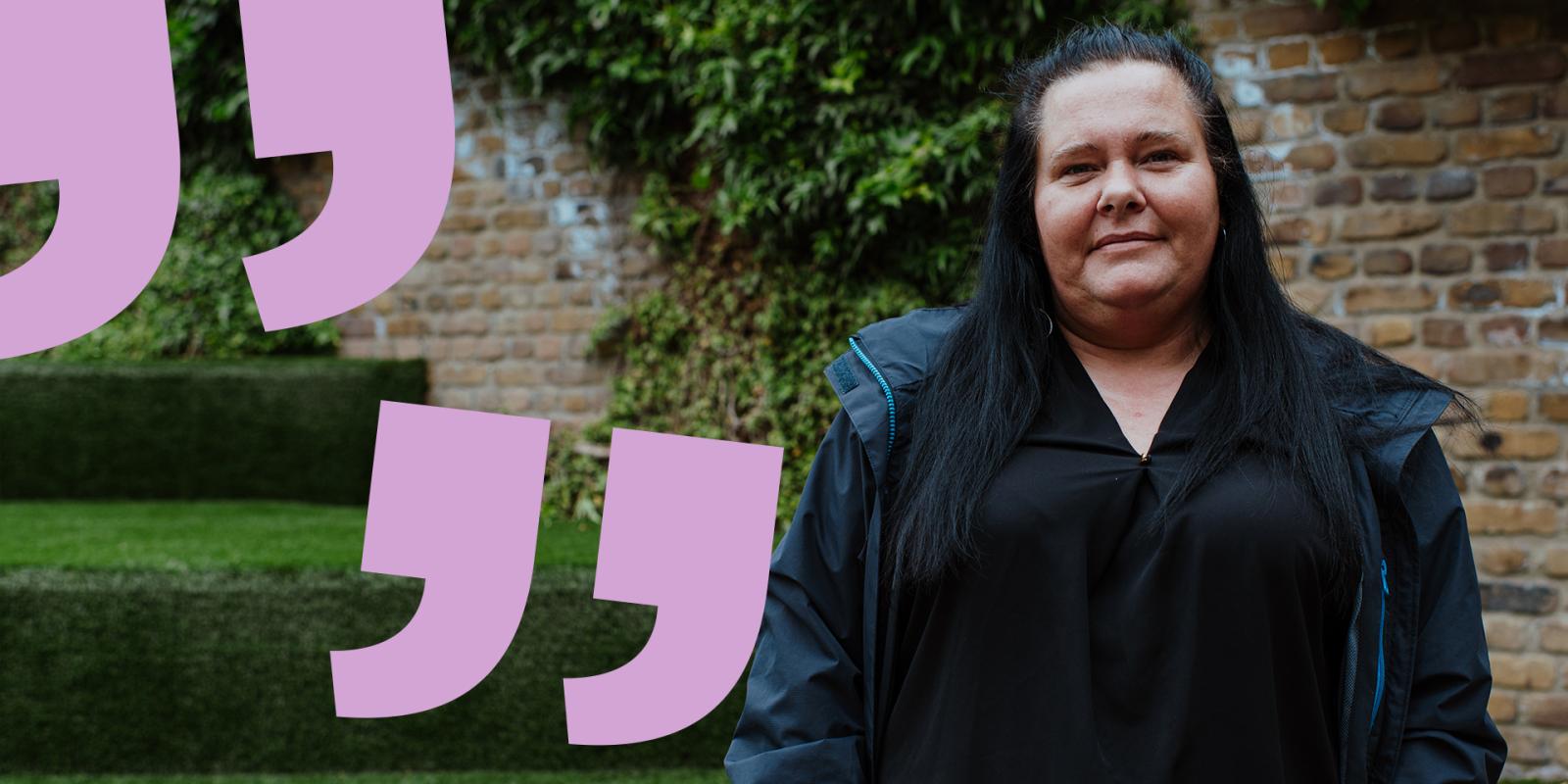 Gemma with a gentle smile in a walled garden looking straight to camera